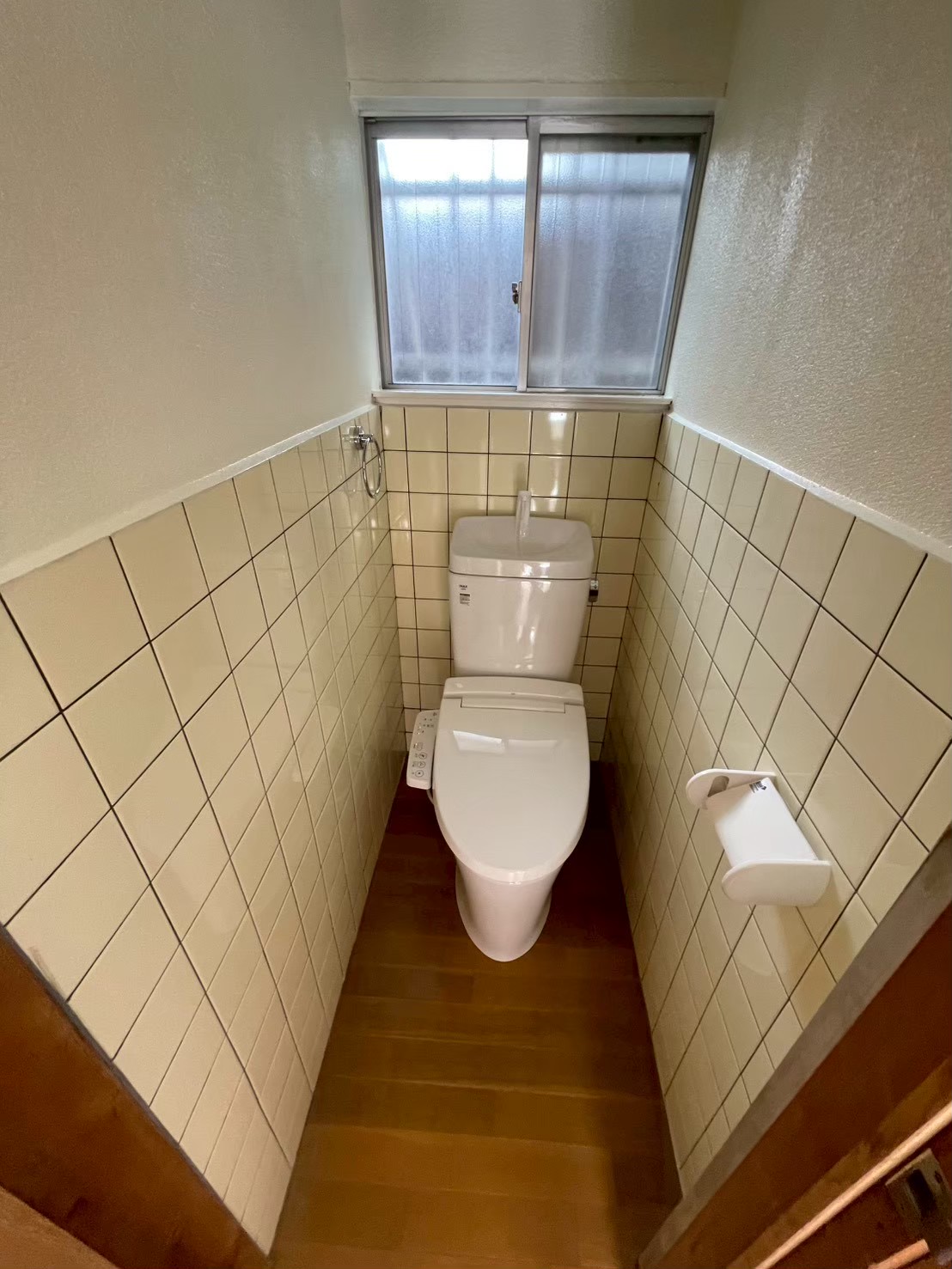 LIXIL アメージュ便器を採用したトイレリフォーム後。既存のタイル壁を残し、タイルより上の壁面を塗装。